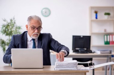 Ofiste çalışan yaşlı bir erkek.
