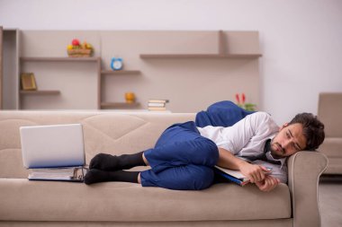 Genç erkek çalışan salgın sırasında evden çalışıyor.