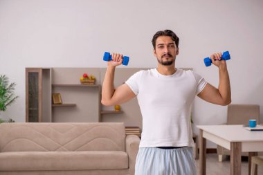 Genç adam evde spor yapıyor.