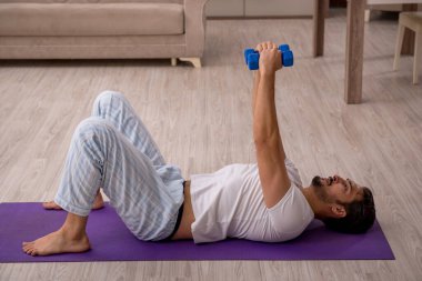 Genç adam evde spor yapıyor.