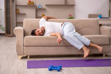 Genç adam evde spor yapıyor.