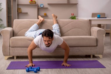Genç adam evde spor yapıyor.