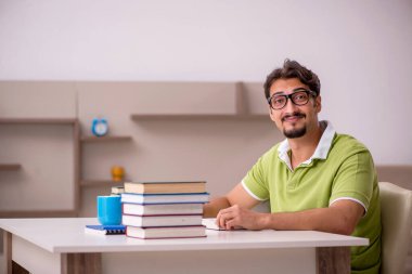 Evde okuyan genç bir erkek öğrenci.