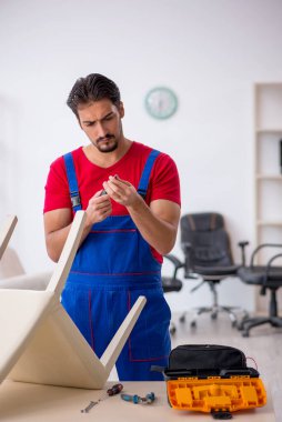 Genç erkek marangoz atölyede çalışıyor.