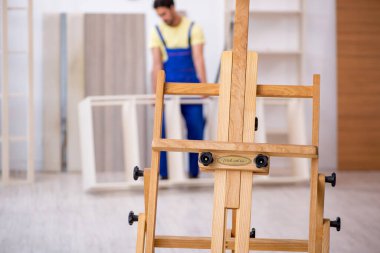 Genç erkek marangoz atölyede çalışıyor.