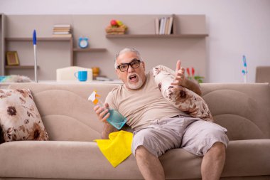 Yaşlı adam evde ev işi yapıyor.