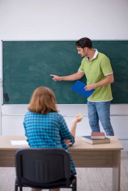 Genç öğretmen ve öğrenci sınıfta.
