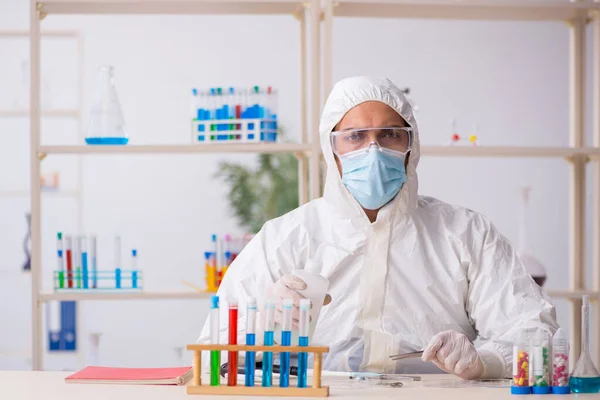 Jovem químico do sexo masculino que trabalha no laboratório durante a pandemia — Fotografia de Stock