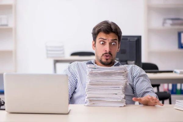 Jonge mannelijke werknemer en te veel werk op kantoor — Stockfoto