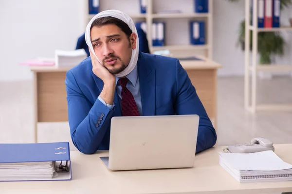 Mladý muž zaměstnanec trpí bolestí zubů na pracovišti — Stock fotografie