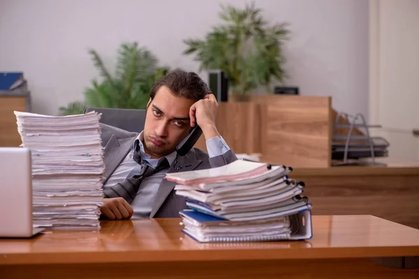Mladý muž zaměstnanec a příliš mnoho práce v kanceláři — Stock fotografie