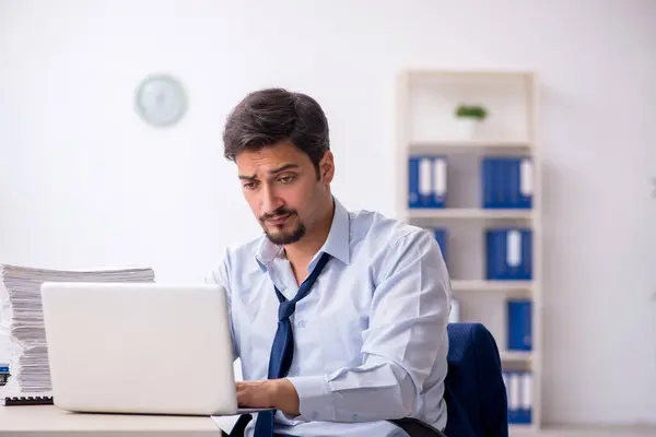 Junge männliche Mitarbeiter und zu viel Arbeit im Büro — Stockfoto