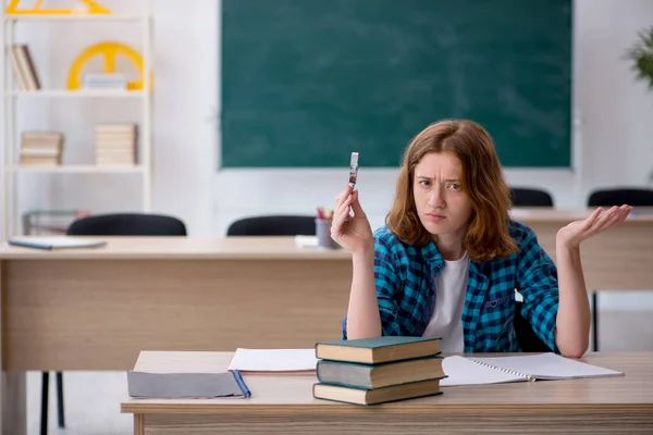 Ung kvinnlig student förbereder sig för tentamen i klassrummet — Stockfoto