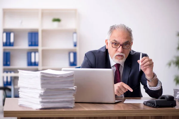 Velho empregado masculino e muito trabalho no escritório — Fotografia de Stock