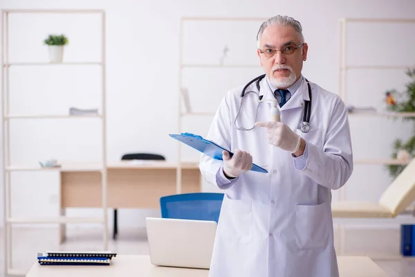 Gammal manlig läkare som arbetar på kliniken — Stockfoto