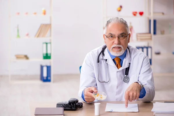 Klinikte çalışan yaşlı erkek doktor. — Stok fotoğraf