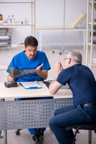 Yaşlı adam genç erkek doktor radyolojisti ziyaret ediyor. — Stok fotoğraf