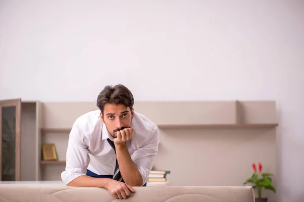 Ung manlig anställd som arbetar hemifrån under en pandemi — Stockfoto