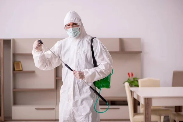 Jovem empreiteiro fazendo controle de pragas em casa — Fotografia de Stock