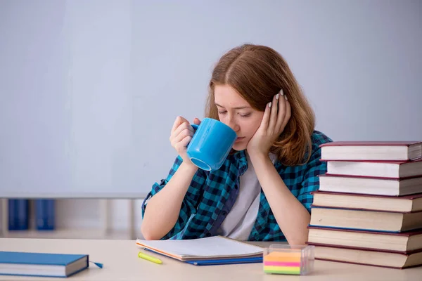 Unga kvinnliga studerande dricker kaffe under pausen — Stockfoto