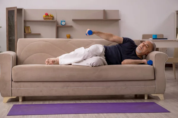 Velho fazendo exercícios esportivos em casa — Fotografia de Stock