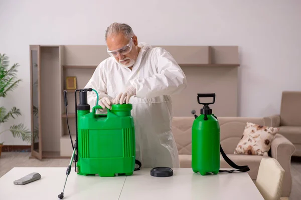 Old male contractor doing pest control at home — Stock Photo, Image