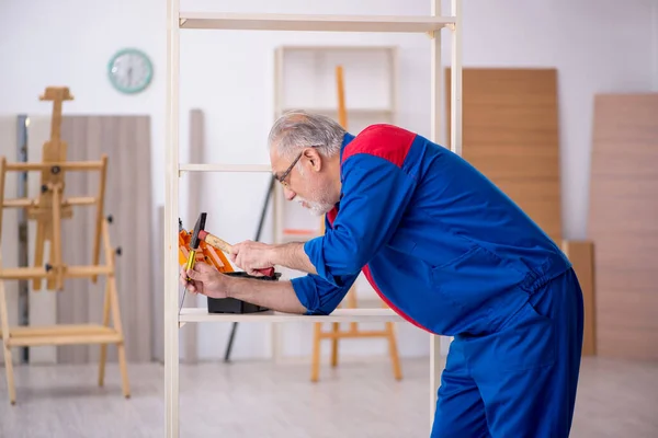 Homem velho carpinteiro trabalhando dentro de casa — Fotografia de Stock