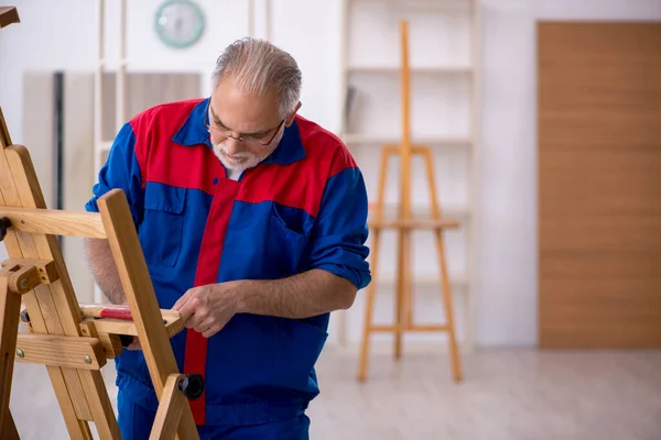 Viejo carpintero reparando caballete de dibujo — Foto de Stock