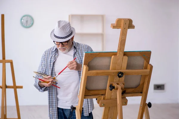 Starzec cieszący się malowaniem w domu — Zdjęcie stockowe