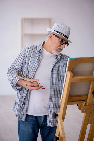 Ο γέρος απολαμβάνει τη ζωγραφική στο σπίτι — Φωτογραφία Αρχείου