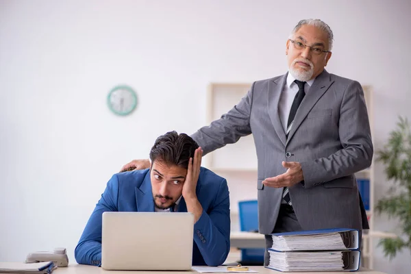 Old male boss and young male employee working in the office — Stock Photo, Image