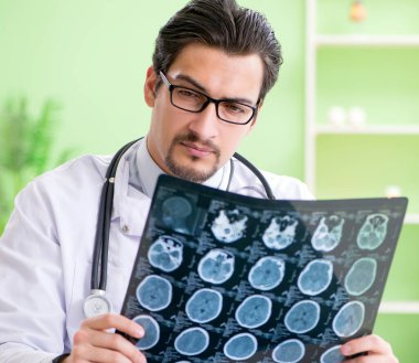 Doktor radyoloji uzmanı hastanede röntgen taramasına bakıyor.