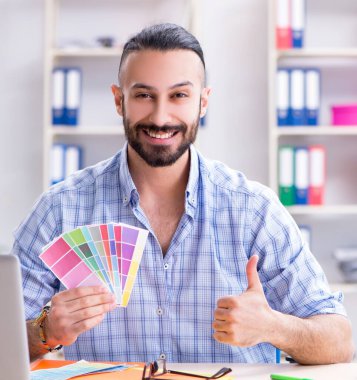 Genç tasarımcı stüdyosunda yeni bir proje üzerinde çalışıyor.