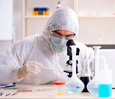 Laboratuvarda çalışan genç yakışıklı kimyager.