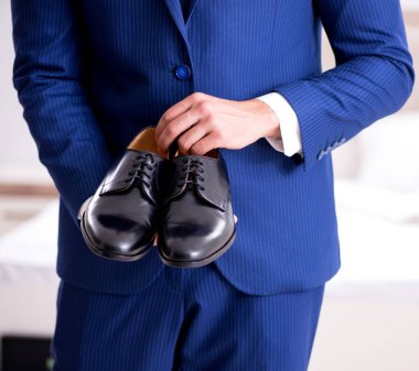 Genç yakışıklı işadamı evde ayakkabı seçimi