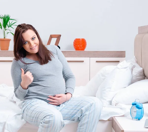 Mujer embarazada joven en el dormitorio — Foto de Stock