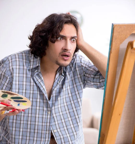 Jovem homem bonito curtindo pintura em casa — Fotografia de Stock