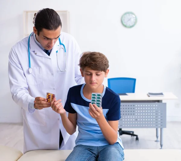 Jovem médico examinando menino na clínica — Fotografia de Stock