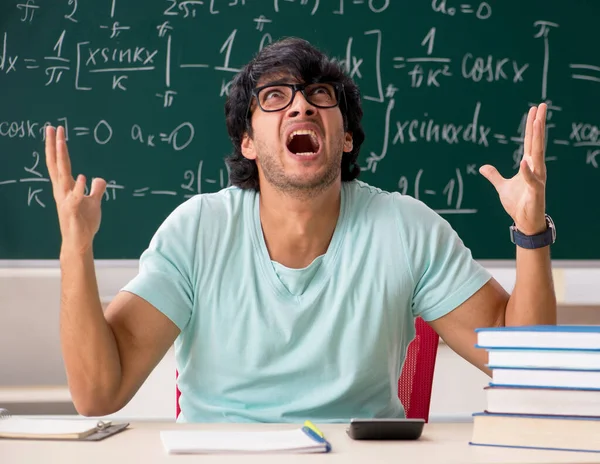 Joven matemático estudiante masculino frente a pizarra — Foto de Stock