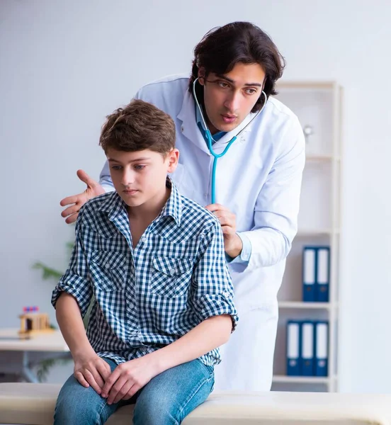 Médico masculino examinando menino por estetoscópio — Fotografia de Stock