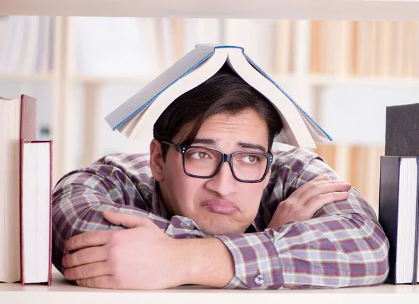 Young student looking for books in college library — Stock Photo, Image