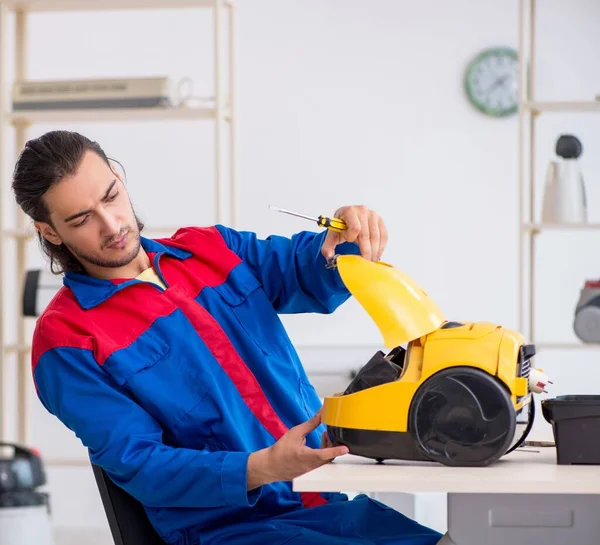 Contratista masculino joven reparando aspiradora en el taller — Foto de Stock