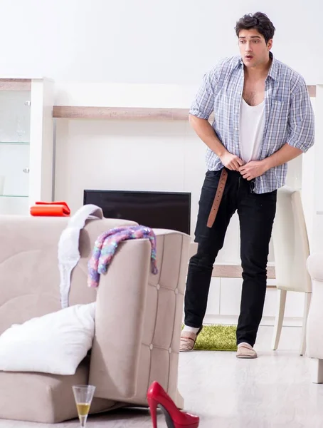 Man with mess at home after house party