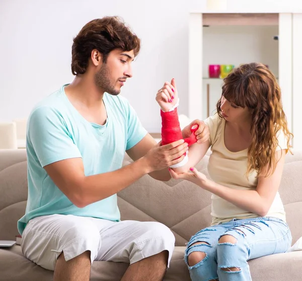 Giovani famiglie che si aiutano a vicenda dopo un infortunio — Foto Stock