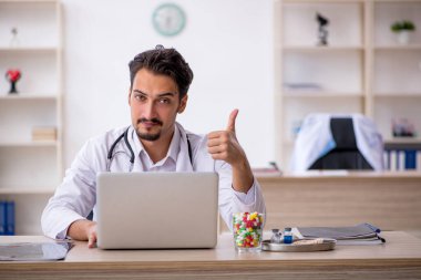 Klinikte çalışan genç erkek doktor.