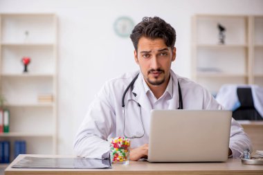 Klinikte çalışan genç erkek doktor.