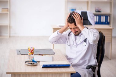 Klinikte çalışan genç erkek doktor.