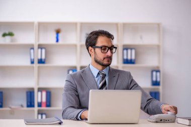 Ofiste çalışan genç bir erkek.