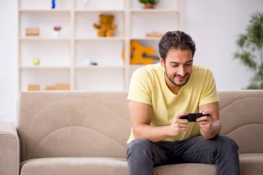 Genç adam salgın sırasında evde oturuyor.