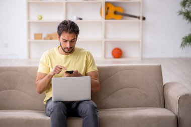 Evde okuyan genç bir erkek öğrenci.